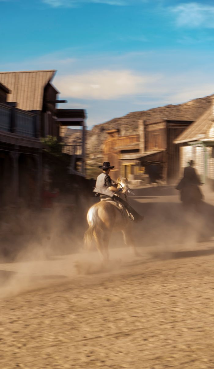 Mastering the First Impression: Your intriguing post title goes here A cowboy on horseback creates dust in a western-style village setting.