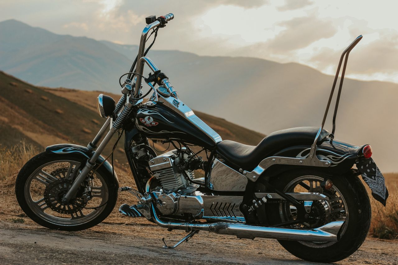 Custom chopper motorcycle parked in a scenic mountainous area in West Azerbaijan, Iran.